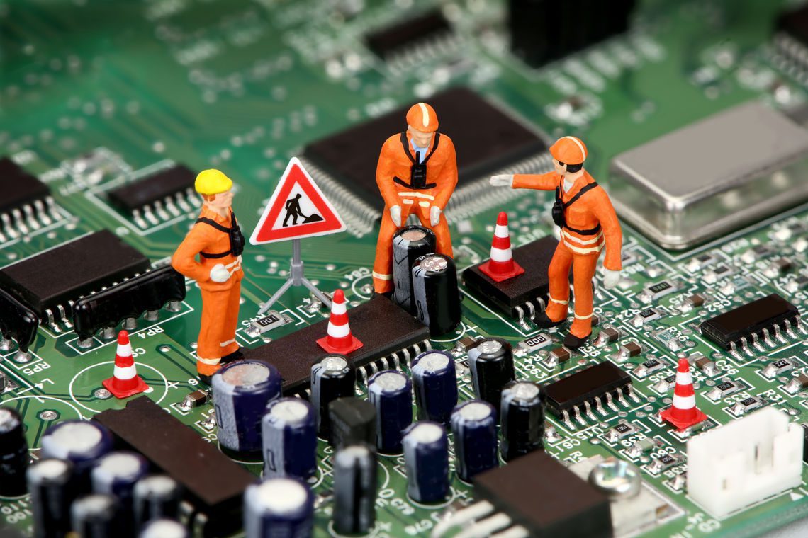 Little construction figures on circuit board