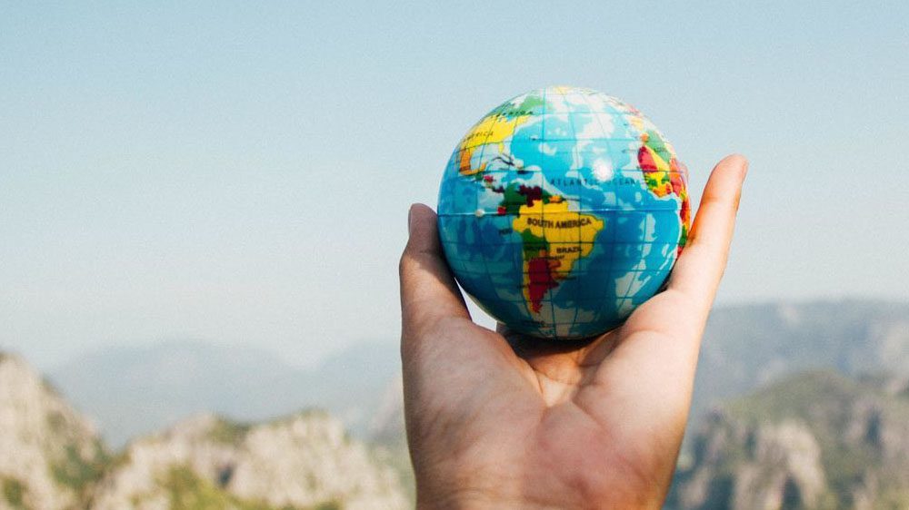 Hand holding a small globe of the world