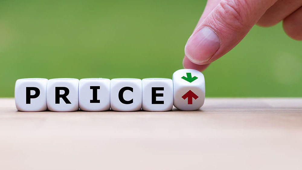 Dice spelling out the word price and another die showing two sides - up and down arrows - and a hand moving the arrows die
