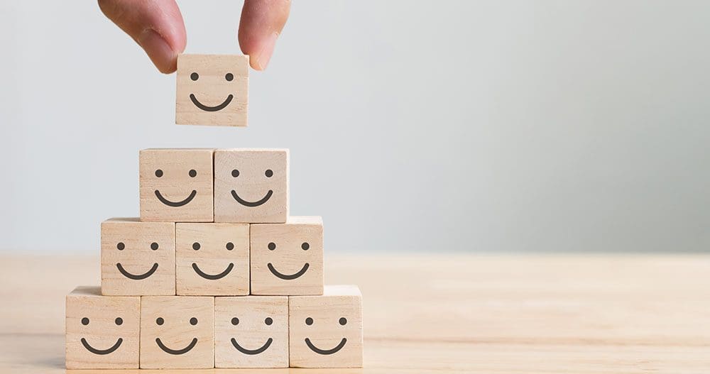 Smiley faces on small wooden blocks in a pyramid