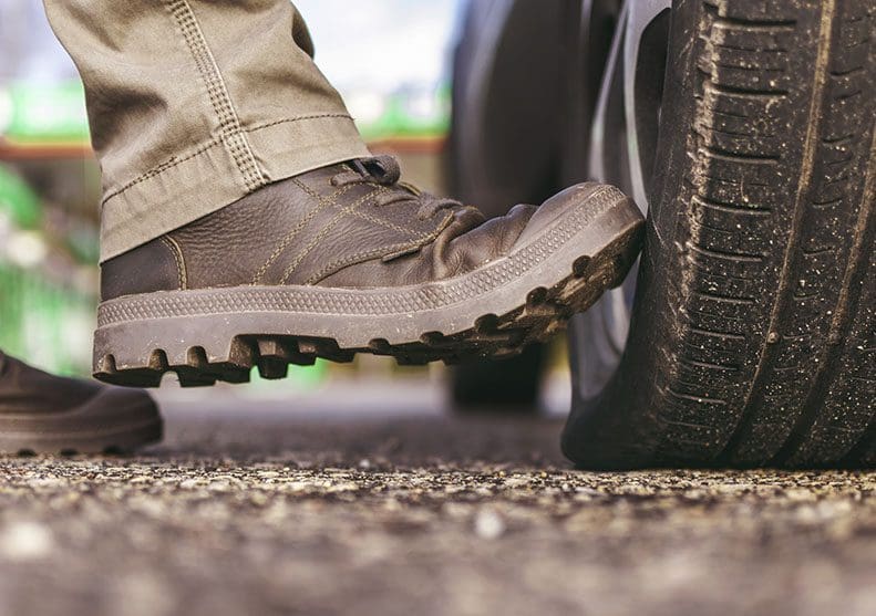 Foot kicking a tire