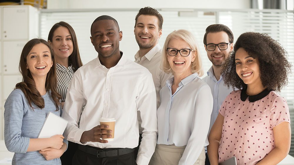 Seven people in office posing for photo