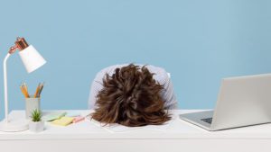 Woman with head down on her desk