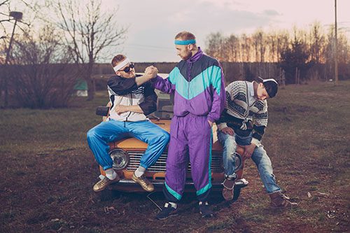 Three men dressed in 1990s fashions