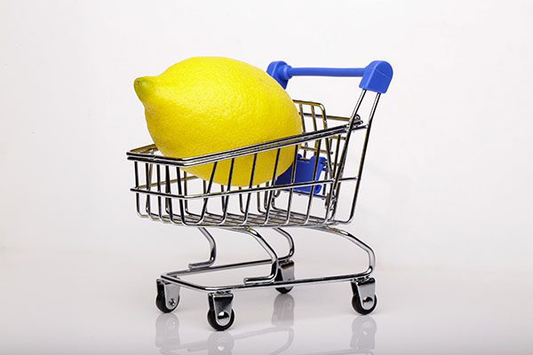 Large lemon in tiny shopping cart