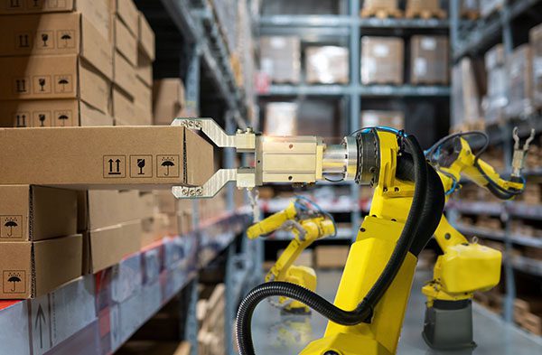 Robotic arm in warehouse pulling box from shelf