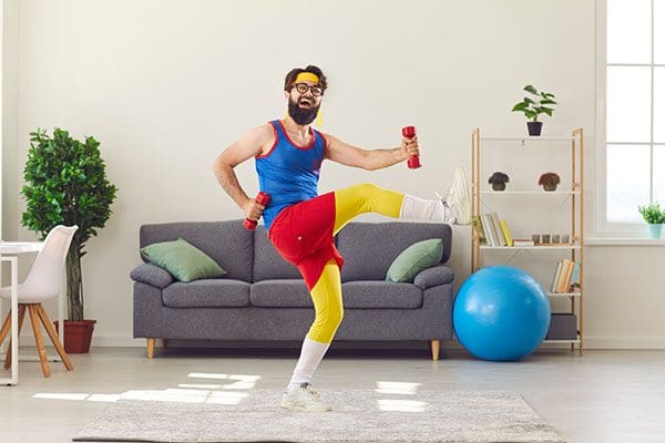 Man in colorful exercise attire using small weights and moving his legs.