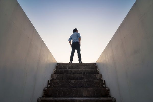 Man at top of stairs leading to outdoors