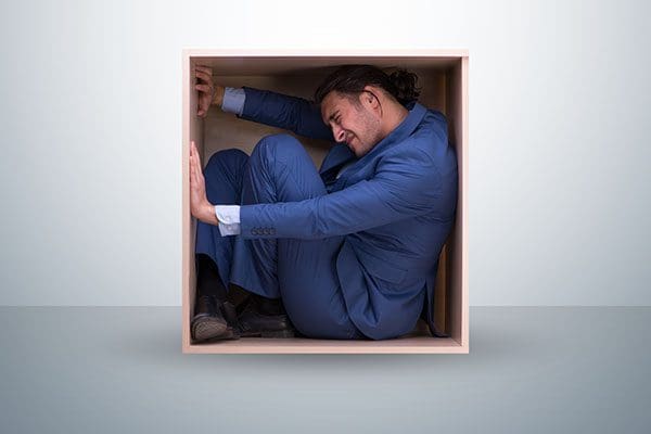 Man in suit squashed inside a box