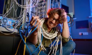 Man in server room with confusing amount of cables