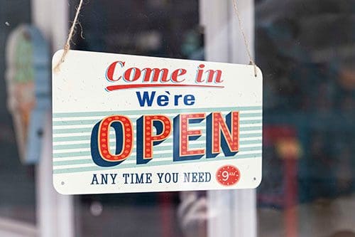Sign in store window reads Come in. We're open any time you need.