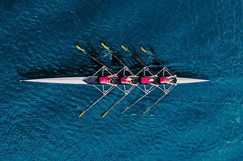 Top view of four-person rowing team on the water