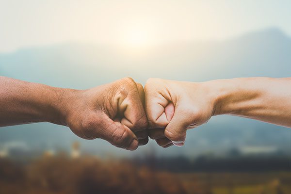 Forearms and hands shown in fist bump